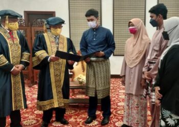 ALIMUDIN Mohd. Dom (dua dari kiri) dan Md. Amin Md. Taff (kiri) melihat Ijazah Sarjana Muda Pendidikan (Sains Kejurulatihan) bersama ahli keluarga arwah Muhammad Raihan Mohd. Rashid selepas Majlis Istiadat Konvokesyen Ke-22 UPSI di Tanjung Malim, Perak, semalam. - IHSAN UPSI