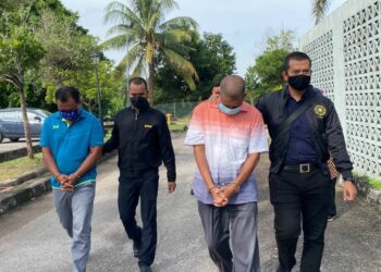DUA bekas pegawai agensi kerajaan yang didakwa terlibat dalam  kes penyelewengan jualan kelapa sawit dibawa di Kompleks Mahkamah Sungai Petani, Kedah, hari ini. - UTUSAN/OTHMAN YAHAYA