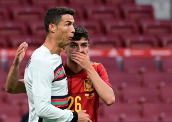 PEMAIN tengah Sepanyol, Pedri (kanan) berkata sesuatu kepada penyerang Portugal, Cristiano Ronaldo dalam aksi persahabatan menjelang Euro 2020 di Stadium Wanda, Madrid  semalam. - AFP