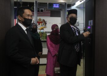 SHAHIDAN Kassim diiringi Jalaluddin Alias (kiri) mengimbas kad perakam waktu pada hari pertama memulakan tugas di Menara Seri Wilayah Kementerian Wilayah Persekutuan, Putrajaya. - UTUSAN/FAISOL MUSTAFA