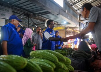 T. MOHAN (kiri) bersalaman dengan peniaga semasa berkempen di Kuala Kubu Bharu, Selangor, baru-baru ini. – M. FIRDAUS M. JOHARI