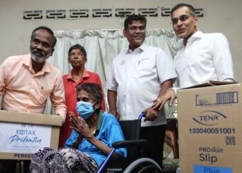 V. SIVAKUMAR menyampaikan sumbangan daripada Perkeso kepada P. Sokkayee di Jalan Meru, Klang. – UTUSAN/AFIQ RAZALI