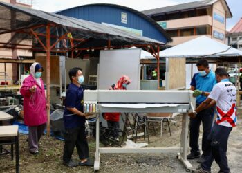 Guru-guru melakukan gotong-royong mengalihkan barangan kegunaan di dalam kelas yang rosak akibat banjir di Sekolah Menengah Kebangsaan Taman Sri Muda, Shah Alam semalam. – UTUSAN/ZULFADHLI ZAKI