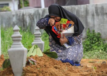 NUR Farah Melissa Mohd. Shukri menangis di pusara bapanya, Mohd. Shukri Ismail di Tanah Perkuburan Islam Kampung Makam Lama, Chabang Tiga, Kuala Terengganu semalam. – UTUSAN/PUQTRA HAIRRY ROSLI