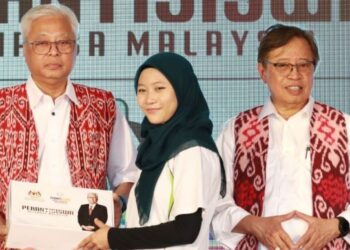 ISMAIL Sabri Yaakob menyerahkan peranti siswa kepada salah penerima selepas merasmikan Lebuhraya Pan Borneo Seksyen Selangau di Selangau, Sarawak, hari ini.
