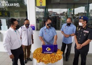 ALEXANDER Nanta Linggi (tengah) menunjukkan buku log yang ditetakkan di Stesen Minyak Petronas di Pasir Pekan, Tumpat, Kelantan, hari ini. - YATIMIN ABDULLAH