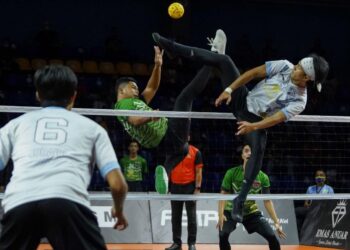 APIT kanan Putrajaya Cyborg, Mohamad Muslim M. Ramli (kanan) melakukan hadangan ketika menentang Kelantan Warriors dalam Liga Sepak Takraw 2021/2022 di Stadium Titiwangsa, Kuala Lumpur semalam. - UTUSAN/FARIZ RUSADIO