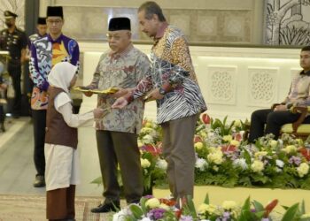 SULTAN Mizan Zainal Abidin mengurniakan bantuan kepada salah seorang pelajar sempena Hari Raya Aidilfitri di Istana Syarqiyyah, Chendering Kuala Terengganu, hari ini. - UTUSAN/KAMALIZA KAMARUDDIN