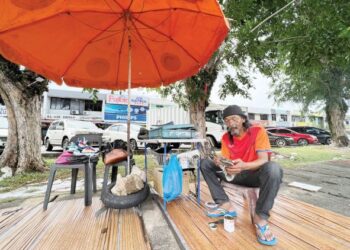 MUSLIM Yahya tekun membaiki kasut para pelanggan sebagai sumber rezekinya di tepi jalan berhampiran bulatan Jubli Emas, Kangar, Perlis semalam.- UTUSAN/MOHD. HAFIZ ABD. MUTALIB