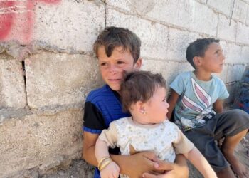 SEORANG kanak-kanak pelarian memangku adiknya di sebuah kem pelarian di Jarabulus, Syria. – MINGGUAN/METRA SYAHRIL MOHAMED