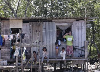 SEORANG warga emas bersama empat kanak-kanak dipercayai cucunya di hadapan rumah mereka di Batu 30, Sandakan, Sabah. Batu 30 menjadi tumpuan pendatang asing dari Filipina. - MINGGUAN/FAUZAN AZIMA