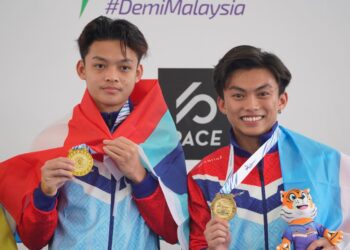 GANDINGAN Julfaddli Jali dan Gabriel Gilbert Daim meraikan kejayaan meraih pingat emas 3 meter papan anjal seirama Sukma 2022 di Pusat Akuatik Nasional Bukit Jalil semalam. - UTUSAN/AMIR KHALID