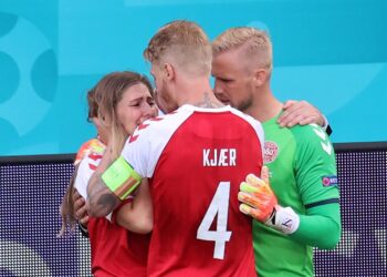 KASPER Kasper Schmeichel (kanan) dan Simon Kjaer menenangkan Sabrina Kvist Jensen selepas Christian Eriksen rebah semalam. - AFP