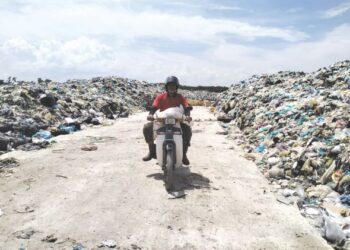 ABDULLAH Yusof menunggang motosikal di laluan yang disediakan di tempat pelupusan sampah yang kini lebih sistematik di Kampung Kok Bedollah, Tumpat, Kelantan. – UTUSAN/ROHANA ISMAIL