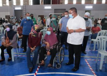 MUHAMMAD Sanusi Md. Nor bertanya sesuatu kepada salah seorang penerima vaksin ketika melawat PPV Mega di Amanjaya Sports Arena, Sungai Petani, Kedah, hari ini. - UTUSAN/SHAHIR NOORDIN