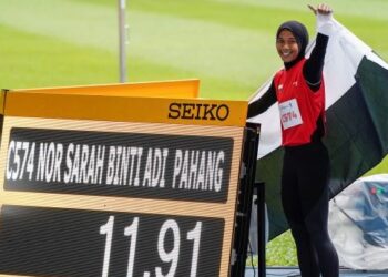 NOR Sarah Adi bergambar bersama catatan yang dilakukan ketika memenangi pingat emas 100 meter wanita pada Sukan Malaysia ke-20 di Bukit Jalil hari ini. - UTUSAN/FARIZ RUSADIO