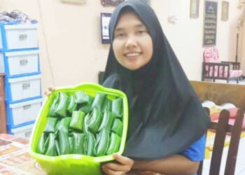 SALINAH Ahmat menunjukkan kelupis yang sudah siap dibungkus menggunakan daun irik di Kota Kinabalu, Sabah.