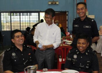 ANUAR Bakri Abdul Salam  (berdiri, kanan) dan Zaifulbahri Idris (dua dari kiri) meraikan anggota Polis Diraja Malaysia Daerah Rembau yang bertugas sebagai barisan hadapan Covid-19 di Rembau, Negeri Sembilan, hari ini.-UTUSAN/NOR AINNA HAMZAH.