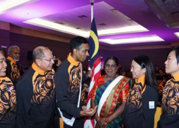 R. Shamendran menerima Jalur Gemilang daripada Hannah Yeoh sambil diperhatikan oleh ibunya, Sambornam Sengodan di Bukit Jalil semalam.