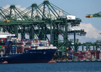 KAPAL sedang memunggah kontena di pelabuhan Singapura. Ketidaktentuan politik dijangka boleh mengancam proses pemulihan ekonomi negara-negara ASEAN termasuk republik itu. – AFP