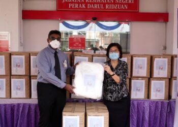 DR. M. PREMANANDA Raja (kiri) menyampaikan sumbangan PPE kepada Dr. Ding Lay Ming di pejabat kesihatan negeri di Ipoh, Perak, hari ini. - FOTO/ZULFACHRI ZULKIFLI