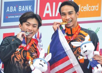 Muhammad Syafiq Puteh (kanan) dan Gabriel Gilbert Daim meraikan kejayaan membawa pulang pingat emas serta perak dalam acara terjun 3 meter papan anjal Sukan SEA 2023 di Pusat Akuatik Morodok Techo, Phnom Penh semalam. – UTUSAN/AMIR KHALID