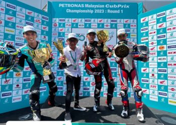 Shahrol Syazras (dua, kanan) meraikan kejayaan menjuarai perlumbaan CP 150 bersama bapanya, Shahrol Yuzy (dua, kiri) pada pusingan pertama Kejuaraan Cub Prix Malaysia 2023 di Litar Antarabangsa Sepang, semalam. - IHSAN CUB PRIX MALAYSIA