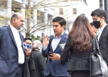 Syed Saddiq Syed Abdul Rahman bersama barisan peguamnya berbincang di luar bangunan Mahkamah Tinggi Kuala Lumpur selepas perbicaraan kes beliau, semalam. – UTUSAN/WAN REDZA