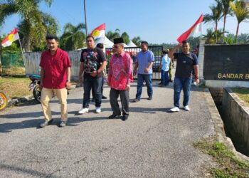 TAJUDDIN Abdul Rahman (tiga dari kiri) beredar setelah dihalang memasuki pekarangan Dewan Besar Bandar Baru Felcra Seberang Perak di Pasir Salak hari ini. - UTUSAN