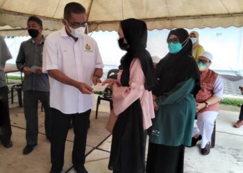 TAKIYUDDIN Hassan menyampaikan sumbangan kepada salah seorang mangsa kebakaran di Jalan Sultanah Zainab di Kota Bharu, Kelantan, hari ini. - UTUSAN/ROHANA MOHD. NAWI