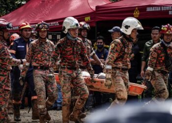 ANGGOTA penyelamat membawa keluar salah satu mayat dalam kejadian tanah runtuh di tapak perkhemahan Father’s Organic Farm, Gohtong Jaya. - UTUSAN/MUHAMAD IQBAL ROSLI