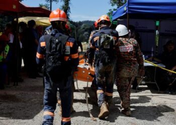 ANGGOTA bomba mengangkat mayat mangsa kejadian tanah runtuh. - JABATAN PENERANGAN
