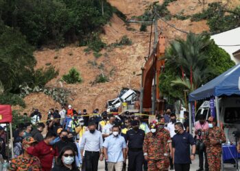 Menteri Besar Selangor, Datuk Seri Amirudin Shari (tengah) keluar dari kawasan yang terjejas akibat tanah runtuh di Taman Bukit Permai yang berlaku lewat petang semalam hingga mengorbankan empat nyawa. -UTUSAN/MUHAMAD IQBAL ROSLI