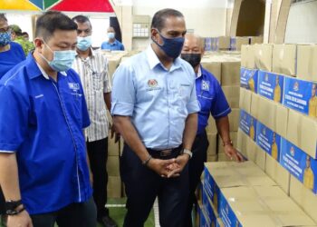 M. SARAVANAN (tengah) melihat kotak makanan untuk diagihkan di Parlimen Tapah di Dewan Gandhi, Tapah, Perak, hari ini. - UTUSAN/ASLIZA MUSA