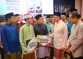 ANWAR Ibrahim (dua, kanan) beramah mesra bersama pelajar asnaf yang menerima dermasiswa zakat pada Majlis Berbuka Puasa Malaysia Madani - Perdana Menteri Bersama Rakyat Terengganu di UMT, Kuala Nerus, malam ini. - UTUSAN/PUQTRA HAIRRY ROSLI