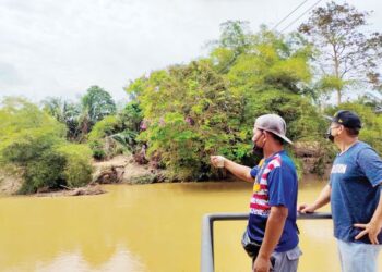 ZAIDIN Zainal Abidin (kiri) menunjukkan kemudahan sukan flying fox menyeberangi sungai di Taman Rekreasi Menuang Bertembuk di Kampung Pasir Besar, Gemas, Negeri Sembilan yang tumbang sejak kerja-kerja tebing sungai dilakukan lebih sebulan lalu. - UTUSAN/NOR AINNA HAMZAH