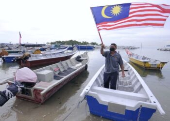 ALIAS Ali mengibarkan Jalur Gemilang di atas perahunya bagi menyemarakkan sambutan Bulan Kebangsaan 2021 di Pangkalan Nelayan Bagan Pinang, Port Dickson, Negeri Sembilan. - UTUSAN/MOHD. SHAHJEHAN MAAMIN