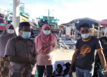 MOHD. Norhisham Hashim (kanan) bersama ahli keluarganya menantikan berita mengenai operasi mencari dan menyelamat adiknya yang masih hilang dalam kejadian bot karam semalam di Jeti Kuala Kurau, Parit Buntar, Perak, hari ini.
