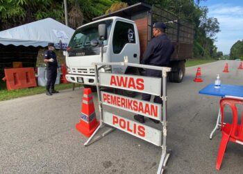 ANGGOTA polis mengadakan kawalan di sekatan jalan raya (SJR) di jalan masuk utama di Bandar Cheneh Baru di Kemaman, hari ini. - UTUSAN/NIK NUR IZZATUL HAZWANI NIK ADNAN