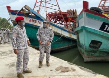 MOHD Zubil Mat Som (kiri) meninjau PTV Maritim Malaysia di Tok Bali, Pasir Puteh, hari ini. - UTUSAN/TOREK SULONG