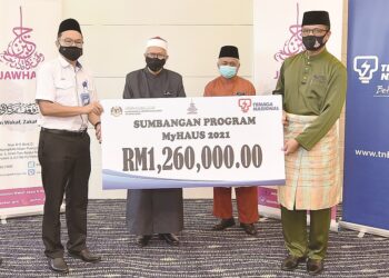 MOHAMAD Ariff Zainol (kiri) menyerahkan replika cek bernilai RM1.26 juta kepada Ruslan Said, sambil disaksikan Zulki i Mohamad Al-Bakri (dua,
kiri) pada Majlis Penyerahan Sumbangan Program MyHAUS 2021 di Putrajaya pada Mei lalu.