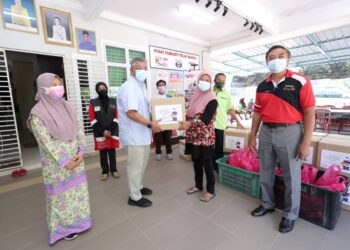 SHAMSUL Ahmad (dua dari kiri) menyampaikan bantuan kotak makanan Program Prihatin Aidiladha TNBJ 1442H di Teluk Muroh, Lumut hari ini. - UTUSAN/SHAMSUL KAMAL AMARUDIN