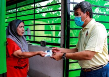 MOHAMAD Hasan menyampaikan sumbangan kepada seorang mangsa banjir kilat di Kampung Stesen, Kuala Sawah, Rantau, Negeri Sembilan semalam.-UTUSAN/MUHAMMAD IZZAT TERMIZIE