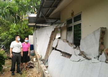NG Poh Lian bersama suaminya, Won Che Bok melihat tembok bahagian belakang rumah mereka yang roboh akibat dirempuh sebuah kereta di Taman Megah Ria, Johor. - UTUSAN/MOHAMAD FAIZAL HASHIM