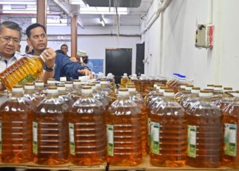SALAHUDDIN Ayub melihat harga minyak botol semasa merasmikan Program Jualan Rahmah di sebuah pasar raya di Kuala Terengganu, baru-baru ini. - FOTO/PUQTRA HAIRRY