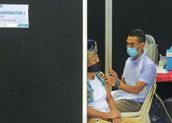 Seorang penduduk di Kuala Terengganu menerima suntikan dos penggalak vaksin Covid-19 di Dewan Serbaguna PPR Hiliran, semalam. - UTUSAN/PUQTRA