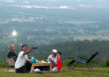 SEBAHAGIAN ahli keluarga menikmati hidangan berbuka puasa di atas puncak Bukit Maras, Kuala Nerus, Terengganu.