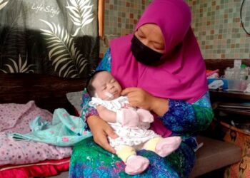 SUNIRA Musaraini Mustaffa bersama bayinya, Qaseh Nurhawa yang menghidap pelbagai komplikasi penyakit di kediaman mereka di Kampung Bukit Kolam, Ajil, Hulu Terengganu, semalam. - UTUSAN/NOOR HAYATI MAMAT