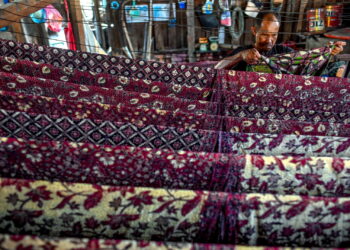 KUALA NERUS 9 Ogos 2022 - Pekerja Wan Azhar Batik, Yazli Mohd Abu Ghani, 47, menjemur kain batik untuk dikeringkan di ampaian di bengkel yang terletak  di Kampung Seberang Takir. -UTUSAN/PUQTRA HAIRRY