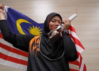 NURUL Syasya Nadiah Mohd. Arifin meraikan kejayaan memenangi pingat emas acara menembak 10 meter air pistol wanita pada Sukan SEA 2021 di Hanoi hari ini. -  UTUSAN/SHIDDIEQIN ZON